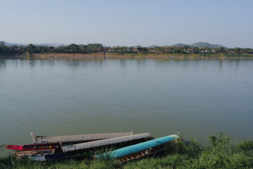 Obraz premium Traditional wooden boat river waterfront calm water nature countryside rural landscape reflection peaceful