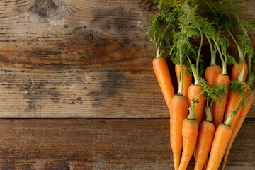 新鮮な葉付きにんじん(木目背景)