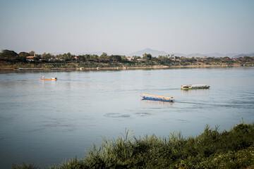 Fototapeta premium Calm river long boat water transport nature landscape travel mountain reflection rural