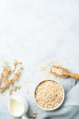 Rolled oats flakes in a wooden bowl with ears.