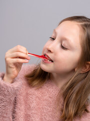 Smiling girl holding gummy candy and looking at camera in studio. Sweet snack, happy child, colorful treat, dessert time, playful 