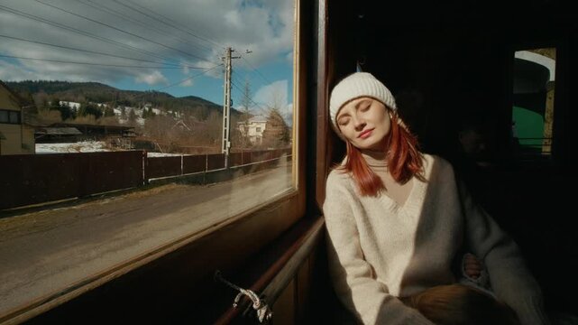 A young mother travels on an old train in Romania, holding her sleeping baby boy close. They enjoy a journey through beautiful landscapes and charming villages.