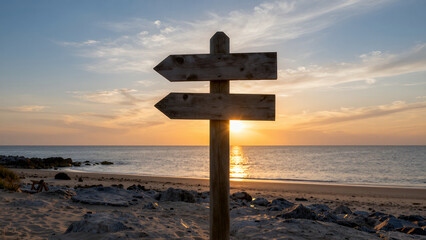 Wooden Signpost On Sandy Beach During Sunset With Ocean And Sky In The Background
