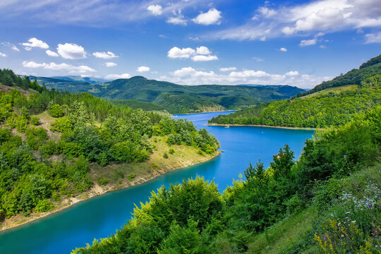 Panoramic landscape of Lake Zavoj surrounded by forested hills and mountains near Pirot in southeastern Serbia under blue sky