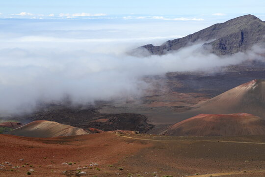 The Sliding Sands trail leads into the drier part of the crater as clouds and tropical moisture surround the wetter, Eastern side of the Haleakala crater in Hawaii
