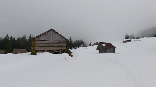 Rustic Abandoned Cabins in Snowy Mountain Landscape