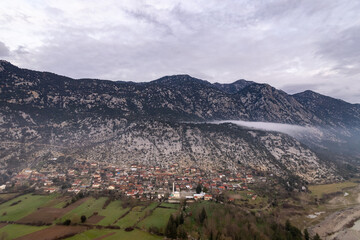 Obraz premium A panoramic view capturing the harmony of rural life, featuring the green agricultural fields of Çaltepe village alongside the Köprüçay river and the historic St Paul Trail in Manavgat, Türkiye