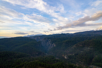 Obraz premium A breathtaking high-altitude drone shot overlooking the vast pine forests and the deep rocky gorge of Koprulu Canyon National Park under a dramatic sky in Antalya, Türkiye