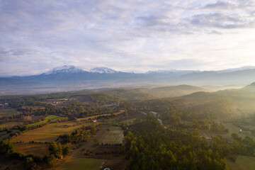 Naklejka premium A stunning drone perspective of Çaltepe village on the St Paul Trail, showcasing the harmony between traditional rural life, green agricultural fields, and the dense pine forests covering the rugged s
