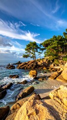 Obraz premium Scenic coastal vista of a rocky shoreline, clear water, and a vibrant sky with wispy clouds. Lush green trees frame the scene