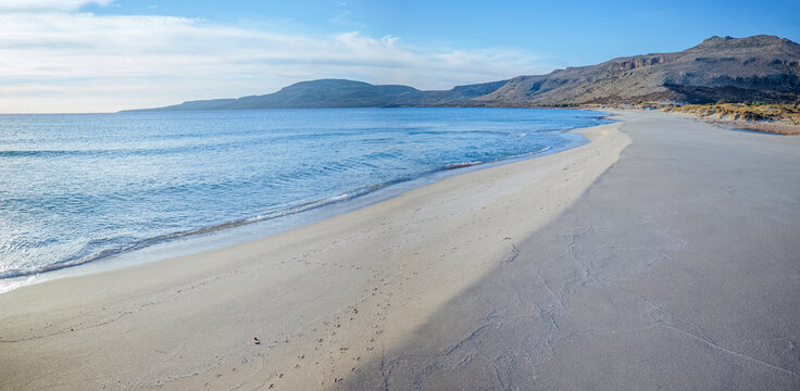 Simos Beach, Elafonisos, Greece: Empty sandy beach with calm blue ocean and hills