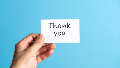 Hand Holding a 'Thank You' Card Against a Bright Blue Background