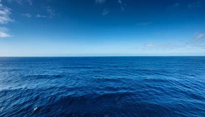 Fototapeta premium vast deep blue ocean stretches to the horizon waves gently rolling under a clear sky perfect for travel nature and serenity themes an endless expanse of calming blue marine serenity