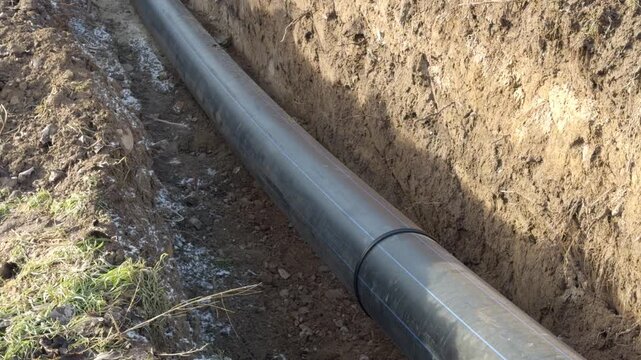Installation of a large diameter water pipeline in a dug trench.