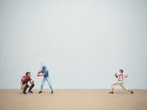 Mini toy of action figure at table with blurred background. Macro toy photography concept design. Minifigure of baseball player character.