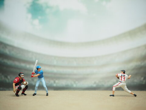 Mini toy of action figure at table with blurred background. Macro toy photography concept design. Minifigure of baseball player character.