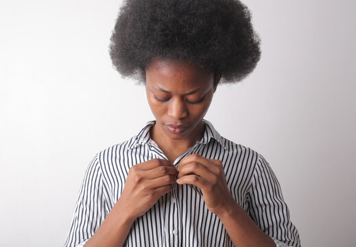 portrait of a woman while tying a blouse