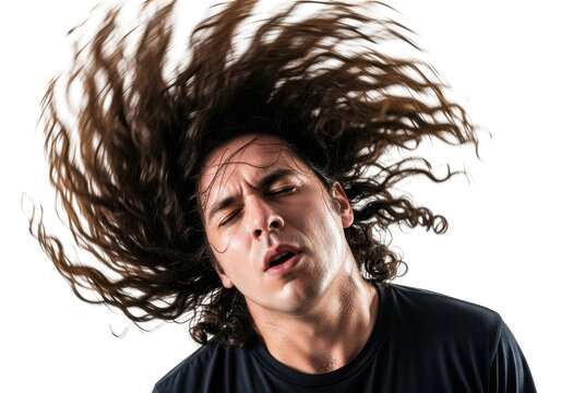 Man with long hair flipping head back in ecstatic motion against a black background