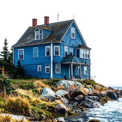 Two-story blue house on a rocky coast with ocean views, clear sky
