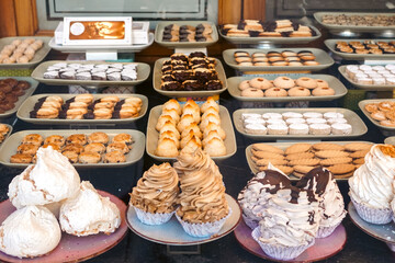 Assortment of different types of meringue cookies on display of a cake shop	