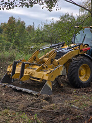 Front loader clearing land at construction site, heavy machinery in action
