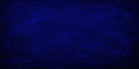 A dark blue grunge background featuring a textured denim fabric pattern with a rough vintage surface reminiscent of a chalk board or weathered cotton canvas wall © PAGLAA