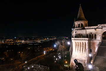 Fisherman's Bastion in Budapest illuminated at night. The historic structure features turrets and arches, surrounded by a quiet plaza. © VasylisaDvoichenkova