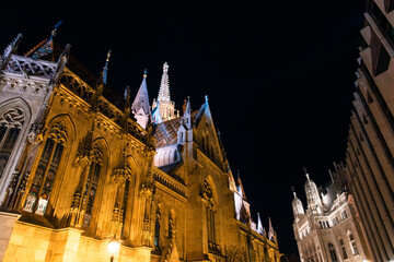 Fisherman's Bastion in Budapest illuminated at night. The historic structure features turrets and arches, surrounded by a quiet plaza. © VasylisaDvoichenkova