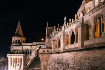 Fisherman's Bastion in Budapest illuminated at night. The historic structure features turrets and arches, surrounded by a quiet plaza. © VasylisaDvoichenkova