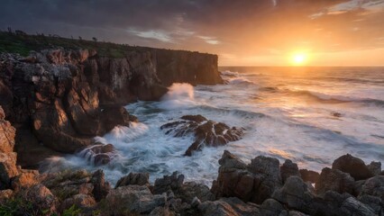 Obraz premium Dramatic ocean waves crash against rocky cliffs at sunset with a golden sun illuminating the sky