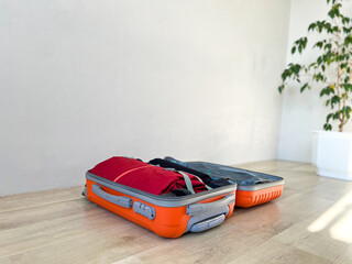 Orange suitcase open and packed for holiday travel