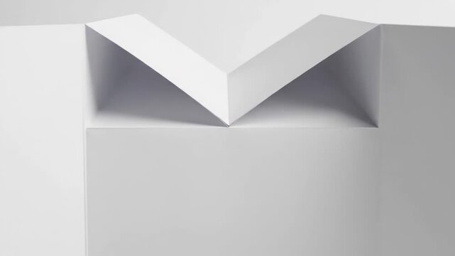 Minimal white folded paper with geometric V shaped form.
