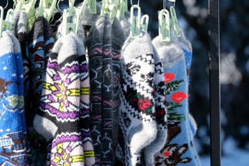 Fototapeta premium Colorful knitted socks hanging in bright winter sunlight