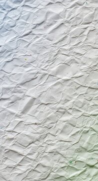 Abstract background featuring a detailed macro view of the distressed, creased surface of a recycled white sheet of paper with many folds, scrap, empty, recycleable