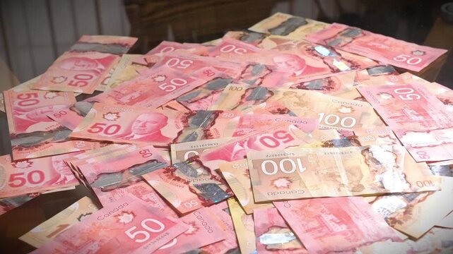 Canadian currency of $50 and $100 polymer bills on a table