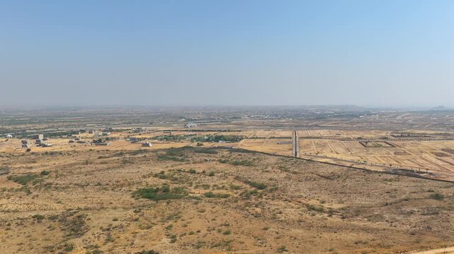 aerial drone footage of a Empty land plots viewed from above during a sunny day showing vast desert with scattered buildings and development plans High quality drone 4k footage