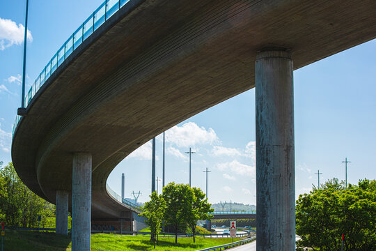 Curved highway overpass bridge with concrete pillars in daylight.