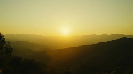 Golden Sunrise Illuminates Mountain Peaks and Valleys with Vibrant Morning Light Under a Clear Sky