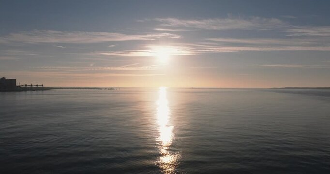 Aerial drone shot golden hour towards Atlantic Ocean horizon and Bugio lighthouse, Estoril and Cascais