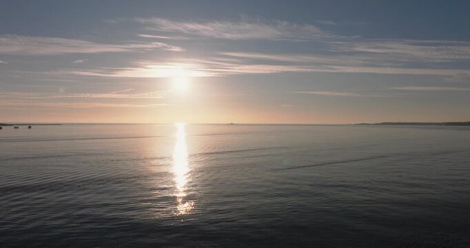 Aerial drone shot golden hour towards Atlantic Ocean horizon and Bugio lighthouse, Estoril and Cascais