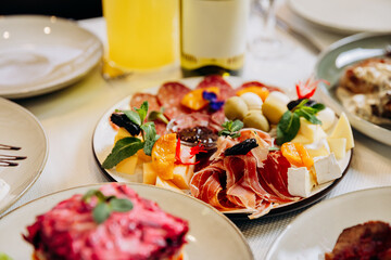 Cheese and meat appetizer platter served on elegant festive restaurant table