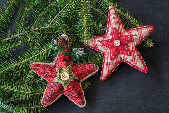 A pair of rustic star ornaments against branches of balsam fir.
