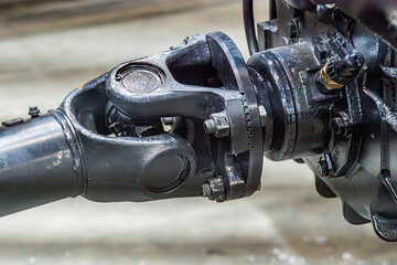 Close-up of intricate mechanical apparatus, muted color scheme, industrial feel, large pipe, label with text, blurred background, metallic object with rivets, foreground focus