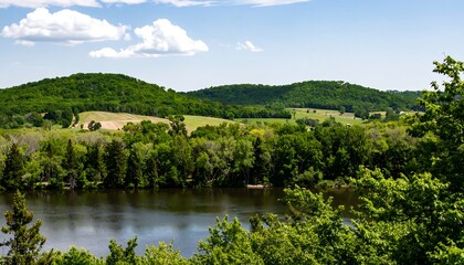 Obraz premium Panoramic view of rolling hills, lush forests, and a calm river
