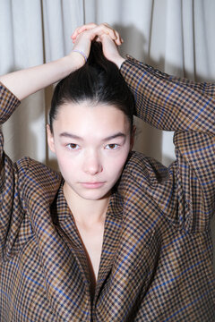 Model prepares for a fashion show by styling her hair