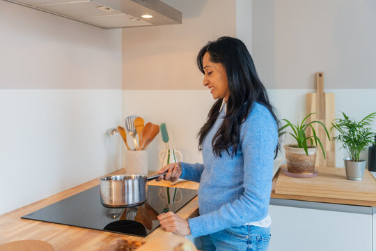 Woman Smiling While Cooking On Stove