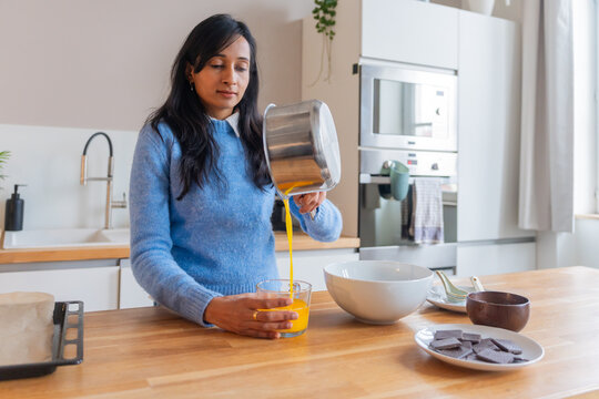 Woman Pouring Melted Butter Into Glass Cup