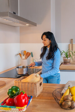 Woman Cooking In Kitchen With Fresh Vegetables