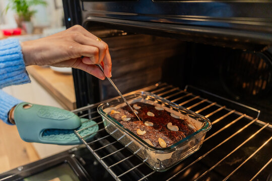 Hand Checking Brownie Doneness In Oven