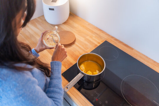 Overhead View Of Woman Melting Butter On Stove